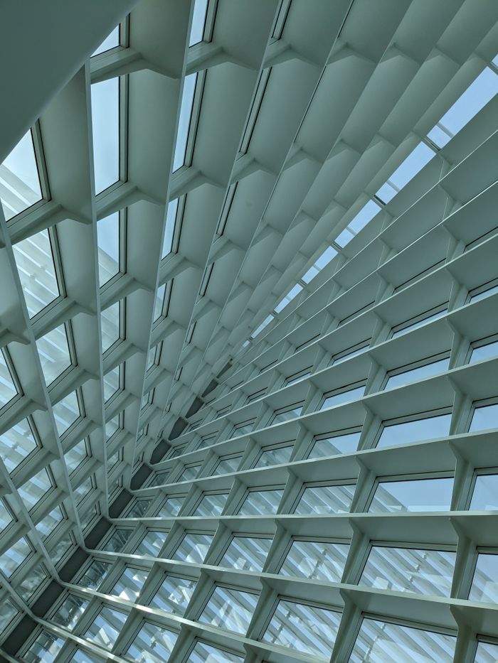 our-story Dynamic architectural design featuring glass and steel structures viewed from below with a modern aesthetic.