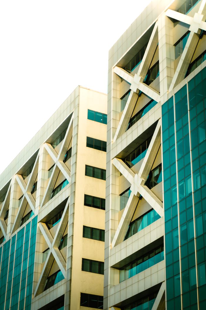 about-bg Close-up view of a modern building facade with geometric patterns and glass elements.